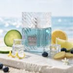 Perfume Lattafa Khamrah Waha en una playa tropical mostrando sus notas frescas y marinas para el calor